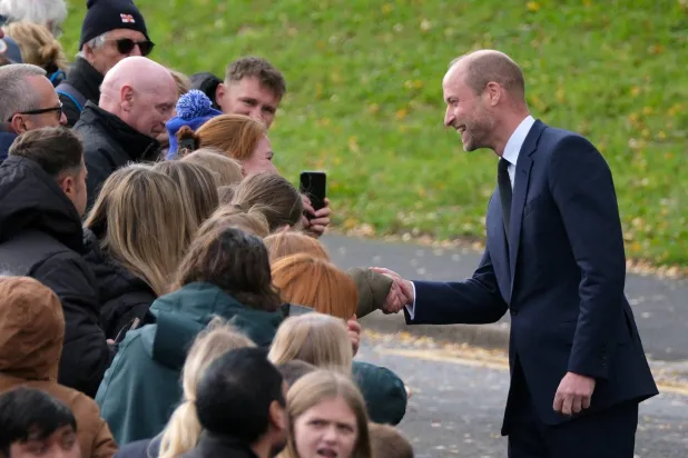 Britain's Prince William meets with the public on a street during a royal visit to the Aberfan Disaster Memorial Garden to mark the 60th anniversary of the 1966 disaster, in which 109 children and five teachers were killed at Pantglas Junior School when a coal spoil tip collapsed onto the Welsh village, Britain, October 21, 2026. (Reuters)
