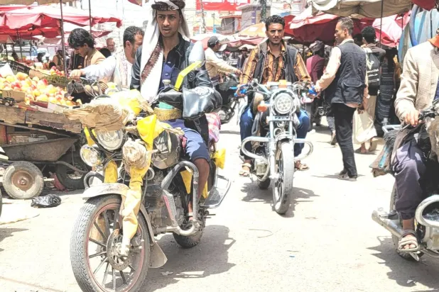 Yemenis on their motorcycles at a market in Sanaa (Asharq Al-Awsat)