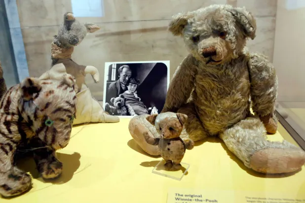 FILE - A photograph of author A. A. Milne with his son Christopher Robin is displayed beside Milne's son Christopher Robin's beloved teddy bear, the inspiration for "Winne-the-Pooh," at the New York Public Library, Monday, Sept. 30, 2013, in New York. (AP Photo/Kathy Willens,File)