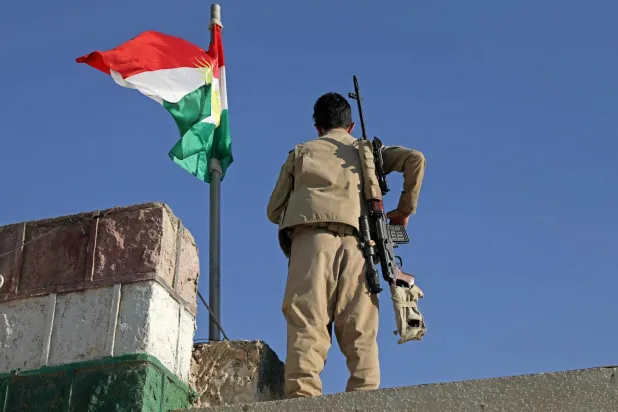A Kurdish peshmerga fighter affiliated with the Iranian Kurdistan Democratic Party (KDP-Iran) stands guard on a building following an Iranian cross-border attack in the town of Koye (Koysinjaq), 100 km east of Erbil, the capital of the autonomous Kurdish region of northern Iraq on October 1, 2022. (AFP)