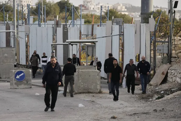 Palestinians cross on foot past a military gate closed to vehicles during an Israeli army operation in Hebron in the occupied West Bank Saturday, Oct. 24, 2026, a day after a Palestinian shooting attack in the area. (AP) 