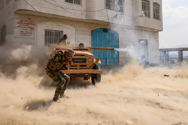 مقاتلون من الحكومة اليمنية في تعز يطلقون قذائف من مدفع مثبَّت على شاحنة نحو المواقع الحوثية (أ.ف.ب)