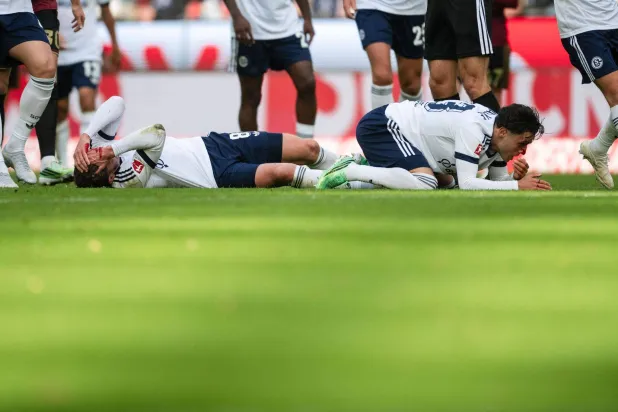 المغربي سفيان الفوزي لاعب فريق شالكه وزميله روبن غوسينس عقب إصابتهما في مواجهة كولن (د.ب.أ)