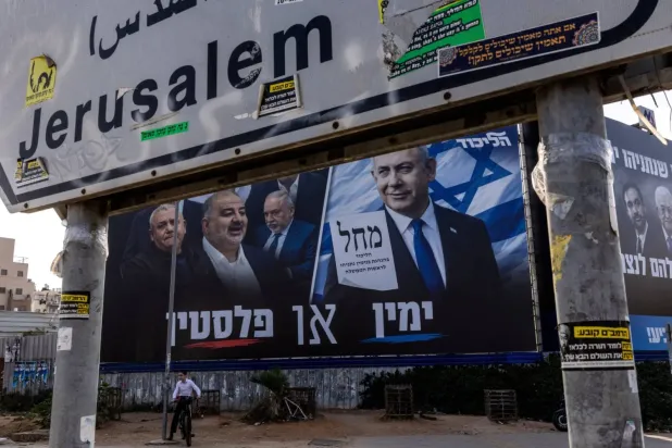 İsrail'in Bney Brak kentinde, parlamento seçimleri öncesinde Netanyahu liderliğindeki Likud Partisi'nin seçim afişinin yanında bisikletiyle bir çocuk (Reuters)