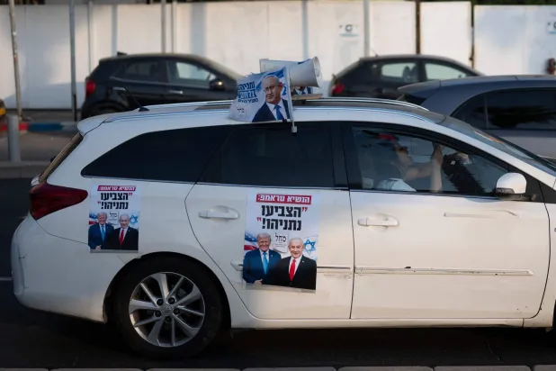 Supporters of Israeli Prime Minister Benjamin Netanyahu's Likud Party drive in a car adorned with campaign posters in Tel Aviv on October 25, 2026, ahead of Israel's legislative election. (AFP)