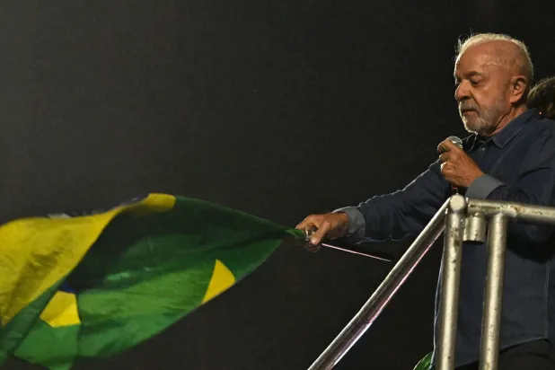 Brazil's President and presidential candidate Luiz Inacio Lula da Silva waves a Brazilian flag as he delivers a speech to supporters after winning the presidential runoff election in Sao Paulo, Brazil, on October 25, 2026. (AFP)