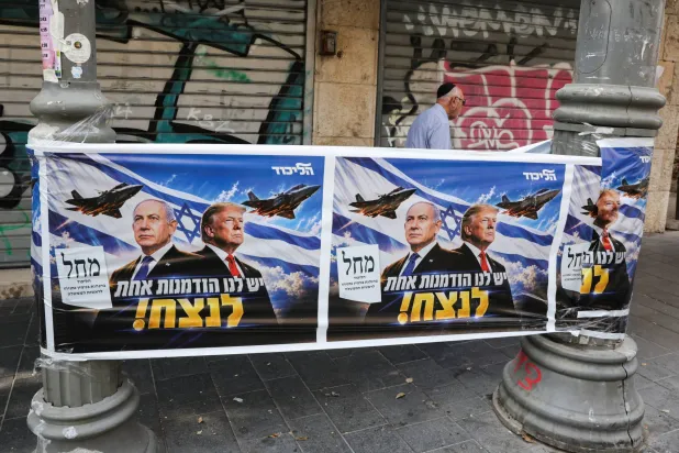  A man walks past a poster of Israeli Prime Minister and Likud party leader Benjamin Netanyahu and US President Donald Trump during the country's national elections in central Jerusalem, October 27, 2026. (Reuters)