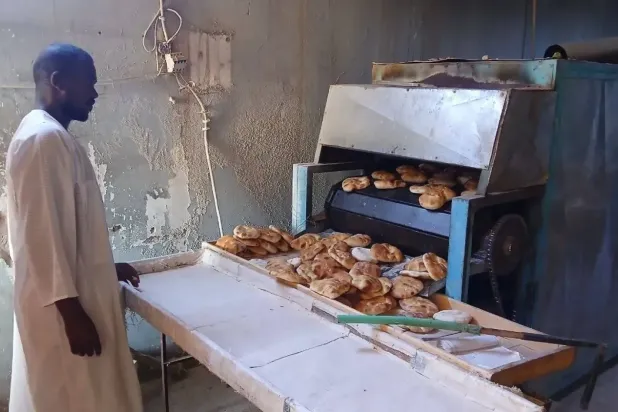 Omdurman’daki bir fırında çalışan işçi, ekmek üretimini denetliyor (Şarku’l Avsat).