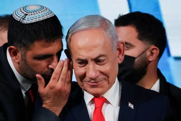 İsrail Başbakanı ve Likud Partisi lideri Binyamin Netanyahu, Kudüs’teki parti genel merkezinde, genel seçimlerde sandık çıkış anketlerinin açıklanmasının ardından basın mensuplarına açıklama yaptığı sırada bir yardımcısı kendisiyle konuşuyor (Reuters)