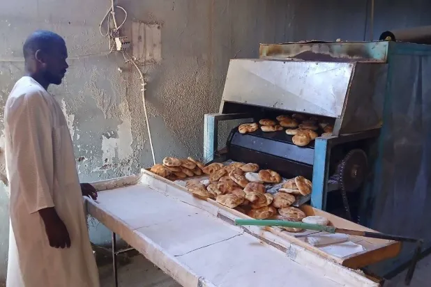 A worker oversees bread production at a bakery in Omdurman (Asharq Al-Awsat)