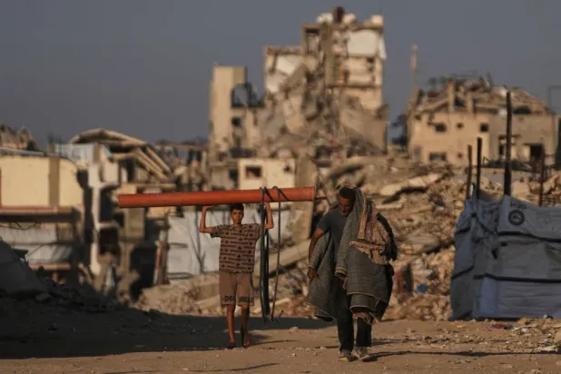 Palestinians walk past buildings destroyed during the Israel-Hamas war in Gaza City Wednesday, Oct. 28, 2026. (AP) 