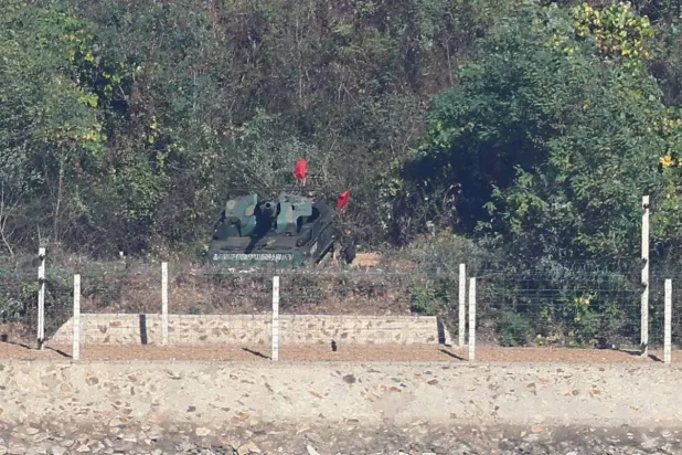 Kuzey Koreli askerler, Güney Kore ile batı sınırına yakın Kaepung’da, kıyı şeridinde düzenlenen tatbikat sırasında kundağı motorlu obüsle eğitim yapıyor (AP)