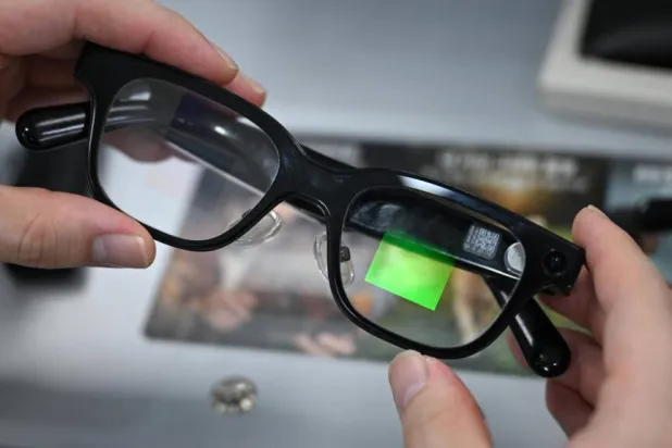 An optometrist holds a pair of smart glasses at the Eyedaq eyewear store in Seoul on Friday. Jung Yeon-je / AFP
