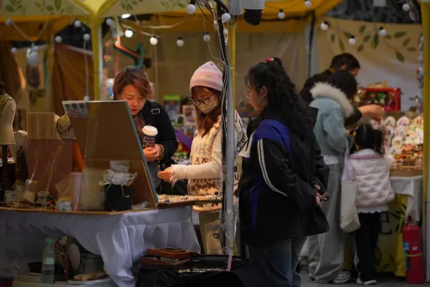  Women shop for fashion accessories at a bazaar held in a popular shopping district in Beijing, Wednesday, Oct. 28, 2026. (AP) 