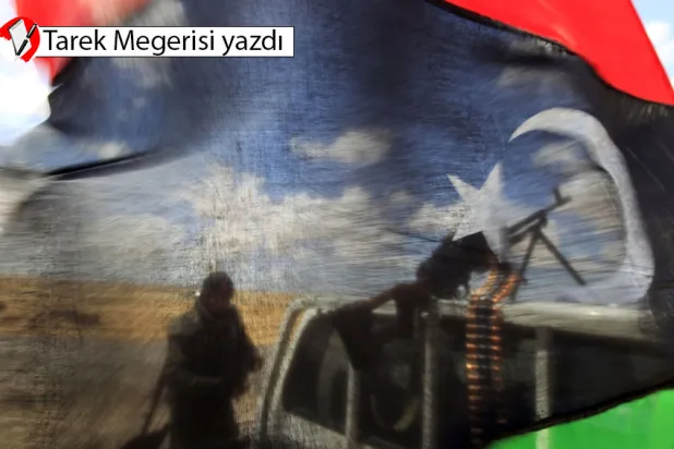 Ecdebiye şehrinin batı kapısında, cephe hattına yakın bir yerde, Libya Krallığı bayrağının arkasında muhalif güçlerden bir savaşçı(Reuters)