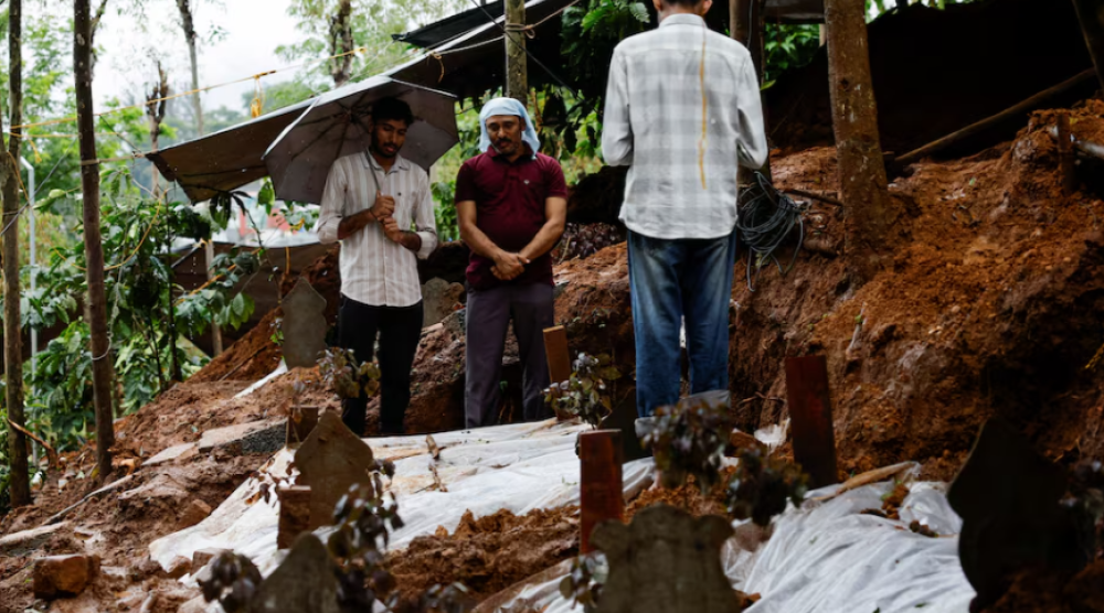 People pray for a departed family member at their grave at a graveyard, after landslides hit several villages in Wayanad district, in Meppadi, in the southern state of Kerala, India, August 2, 2024. REUTERS/Francis Mascarenhas Purchase Licensing Rights