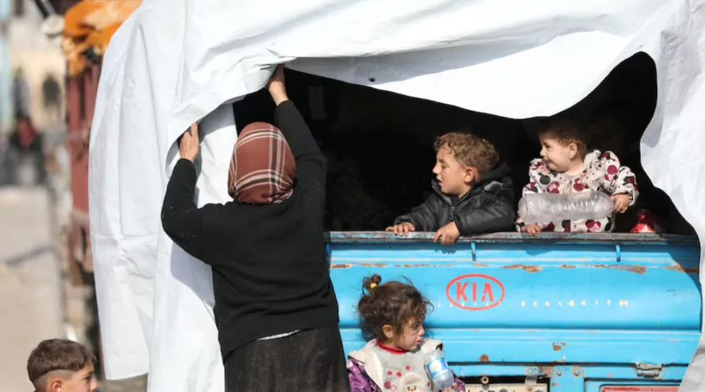 Displaced children who fled the Aleppo countryside, stand at the back of a truck in Tabqa, Syria December 4, 2024. REUTERS/Orhan Qereman P