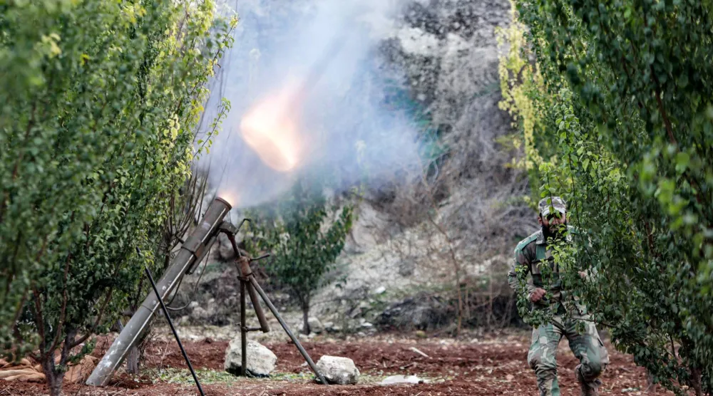 An anti-government fighter fires a rocket against regime forces, in the northern outskirts of Syria's west-central city of Hama on December 4, 2024. (Photo by Bakr AL KASSEM / AFP)