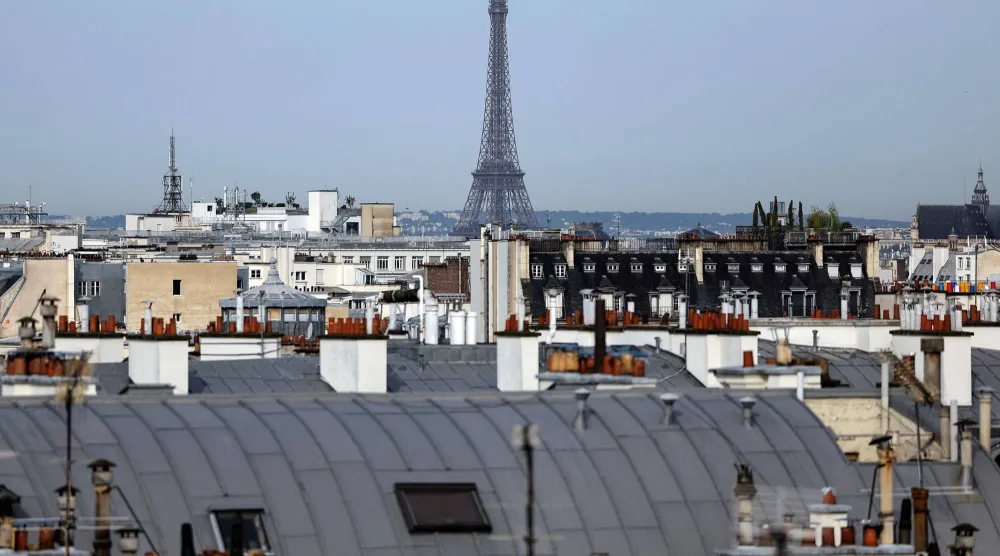 (FILES) A photo shows a view of the Eiffel Tower from the rooftops of Paris, on July 31, 2024. (Photo by Valentine CHAPUIS / AFP)