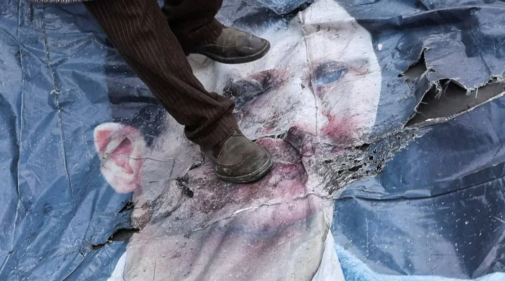 A man walks on a poster of Bashar al-Assad, after Syrian opposition fighters announced that they have ousted Assad, in downtown Damascus, Syria December 10, 2024. (Reuters)