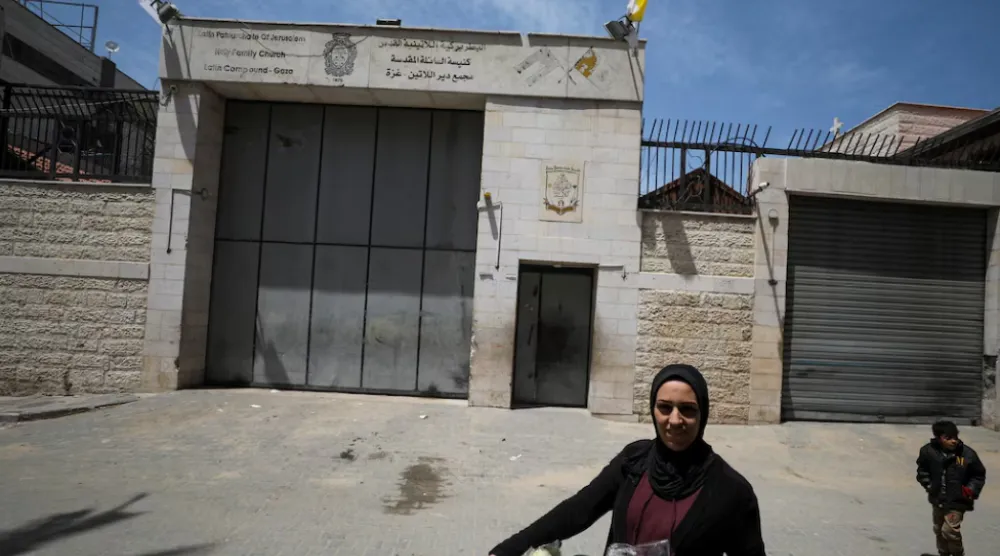 A Palestinian woman walks outside the Holy Family Church after the death of Pope Francis was announced by the Vatican, in Gaza City April 21, 2025. REUTERS/Dawoud Abu Alkas 