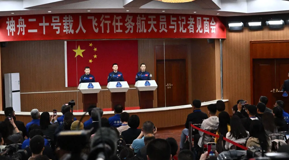 Astronauts for China's Shenzhou-20 space mission (L-R) Wang Jie, Chen Dong and Chen Zhongrui attend a press conference a day before the launch of the mission, at the Jiuquan Satellite Launch Center in the Gobi desert, in northwest China on April 23, 2025. (Photo by Pedro Pardo / AFP)