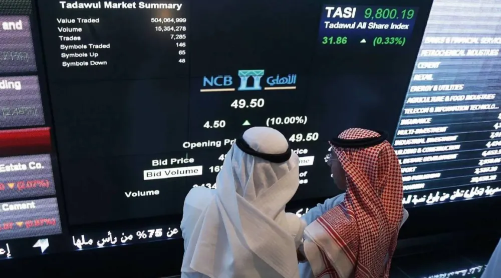 مستثمران في السوق المالية السعودية يراقبان شاشة التداول (أ.ف.ب)