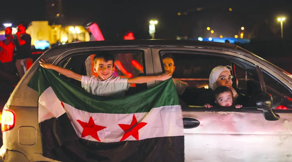 
سوريون يحتفلون في ساحة الأمويين بدمشق بعد قرار الرئيس الأميركي دونالد ترمب رفع العقوبات عن سوريا مايو الماضي (أ.ف.ب)
