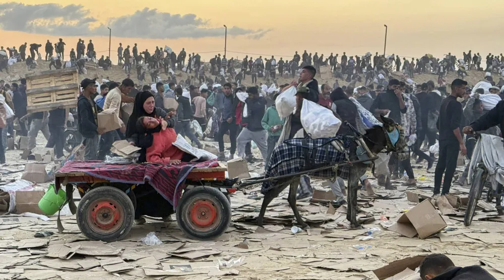 فلسطينية مصابة على ظهر عربة يجرها حمار قرب موقع لتوزيع المساعدات الغذائية بقطاع غزة في يونيو الماضي (أ.ب)
