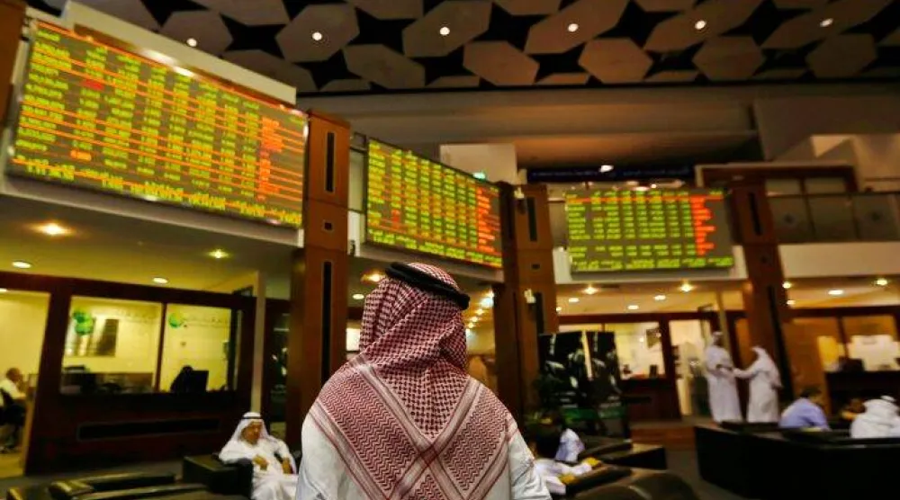 مستثمر ينظر إلى شاشات التداول في سوق دبي المالية (رويترز)