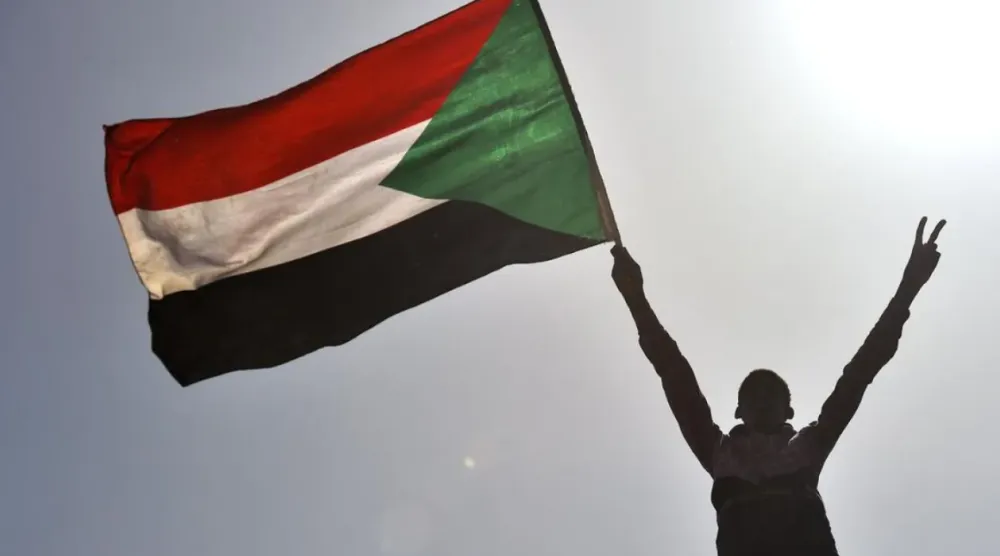 A Sudanese protester waves the national flag near the military headquarters in the capital Khartoum. (AFP)
