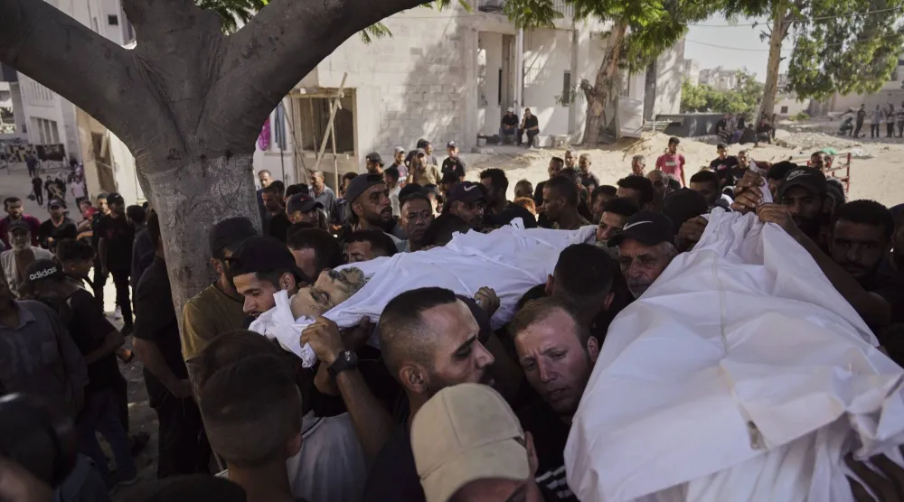 مشيعون يحملون جثامين فلسطينيين قُتلوا في غارة جوية للجيش الإسرائيلي خلال جنازتهم في «مستشفى الشفاء» بمدينة غزة (أ.ب)