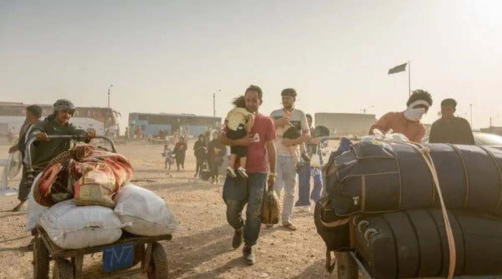 عائدون يعبرون الحدود من إيران إلى إسلام قلعة بأفغانستان يوم الخميس (غيتي)