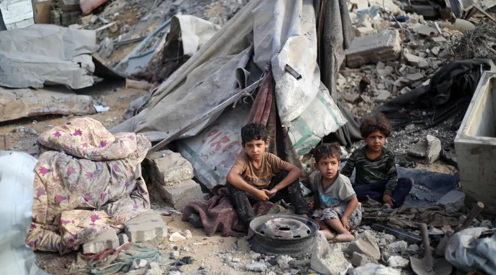 أطفال فلسطينيون وسط الدمار الناجم عن غارة إسرائيلية على مخيم البريج وسط قطاع غزة أمس (أ.ف.ب)