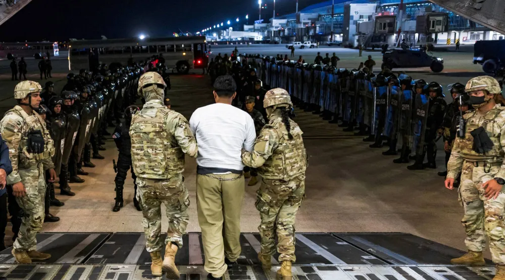 جنود أميركيون يقتادون عضواً يشتبه في انتمائه لعصابة «ترين دي أراغوا» الفنزويلية بغية ترحيله من الولايات المتحدة إلى السلفادور (رويترز)