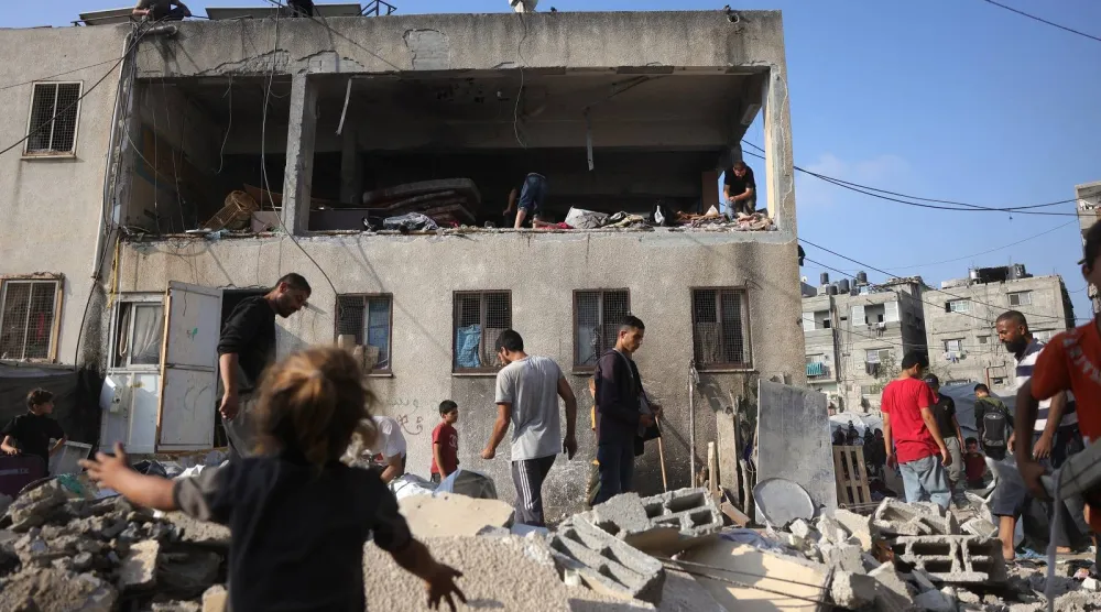 فلسطينيون يتفقدون الأضرار في موقع الغارة الإسرائيلية الليلية على مدرسة حليمة السعدية بجباليا شمال قطاع غزة (أ.ف.ب)
