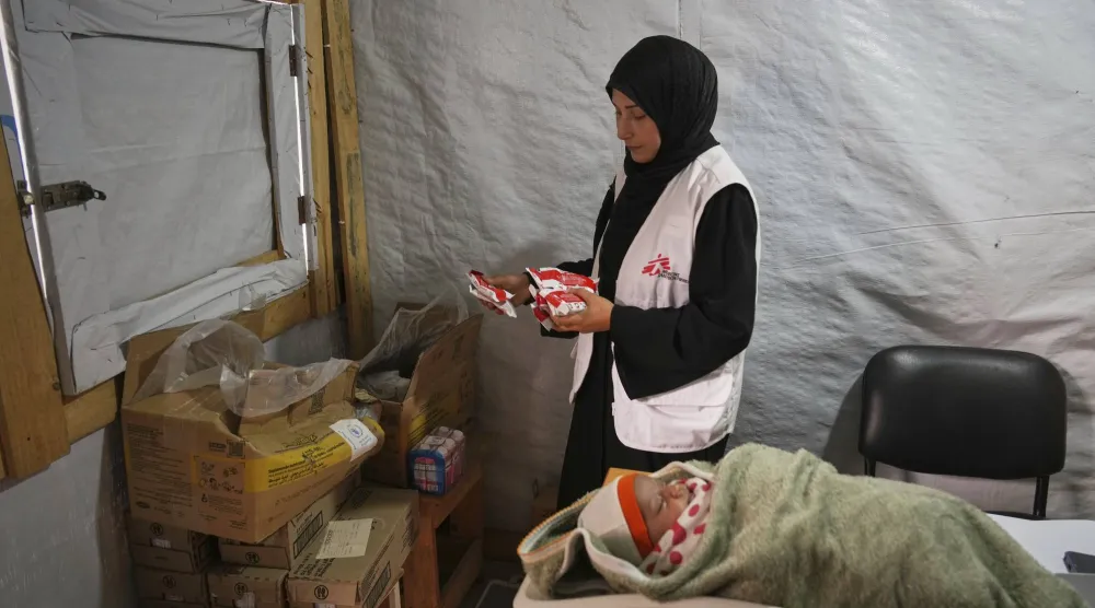 أطباء يزنون طفلاً فلسطينياً في عيادة «أطباء بلا حدود» في المواصي بالقرب من خان يونس في جنوب قطاع غزة (أ.ب)