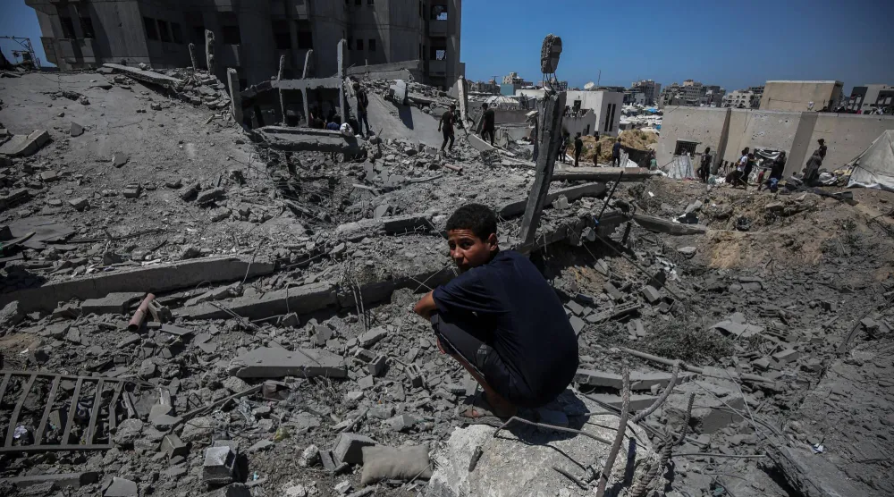 فلسطينيون يتفقدون الدمار الذي لحق بمبان في مدينة غزة (د.ب.أ) 