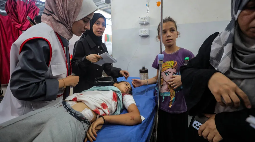 A Palestinian girl, wounded in an Israeli strike that killed people, who gathered to collect water from a distribution point, according to medics, receives treatment at Al-Awda Hospital in Nuseirat in the central Gaza Strip July 13, 2025. REUTERS/Stringer