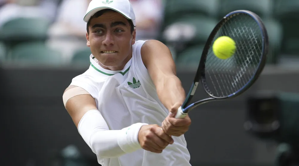 Ivan Ivanov of Bulgaria returns to Ronit Karki of the US in the boys' singles final at the Wimbledon Tennis Championships in London, Sunday, July 13, 2025. (AP Photo/Dave Shopland)