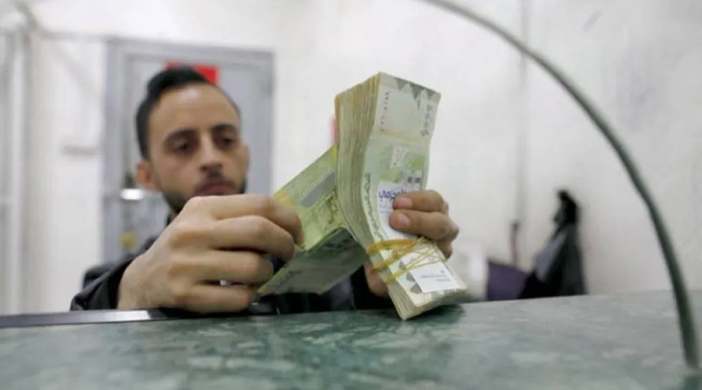 عامل يعد نقوداً في محل للصرافة بصنعاء (إ.ب.أ) 