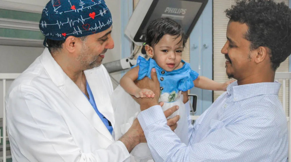 الطفلة جوري مع والدها وقائد الفريق الطبي (وزارة الدفاع)