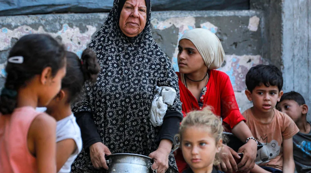 فلسطينيون في مدينة غزة ينتظرون تلقي مساعدات غذائية يوم الاثنين (أ.ف.ب) 