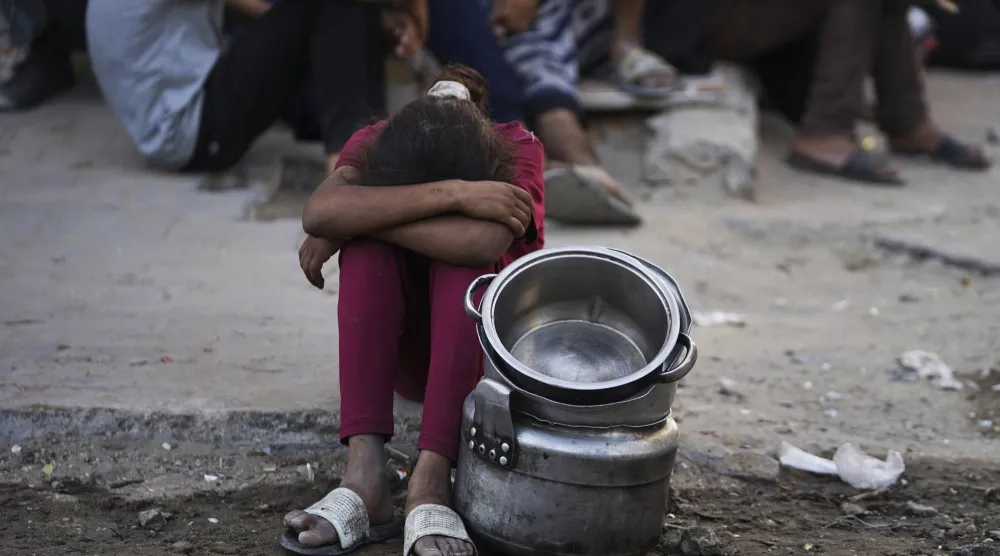 طفلة فلسطينية تنتظر الحصول على غذاء في مدينة غزة (أ.ب)
