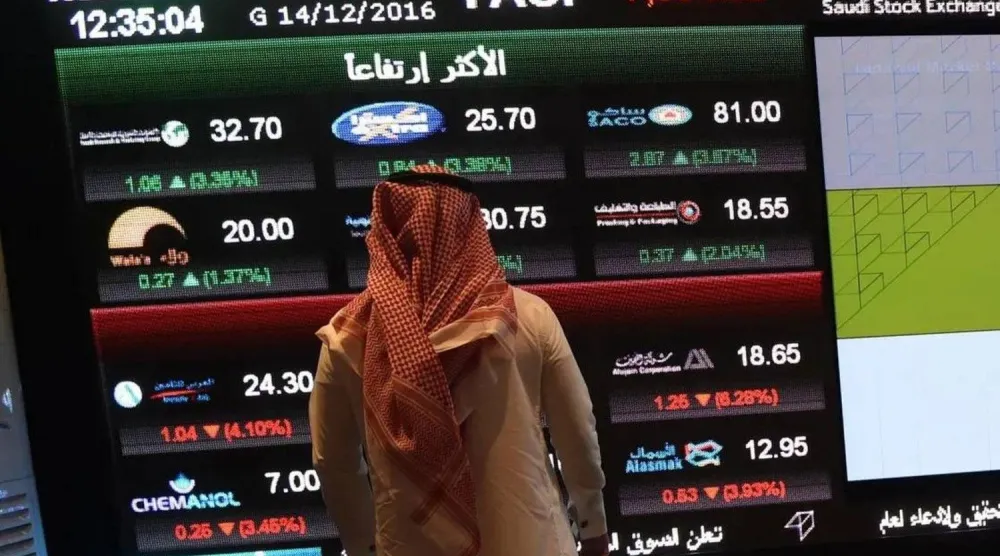مستثمر يراقب شاشات التداول في السوق المالية السعودية (أ.ف.ب)