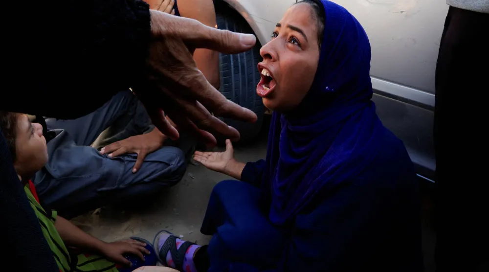 سيدة تنتحب على فقد ذويها في مستشفى الناصر بمدينة خان يونس (رويترز)