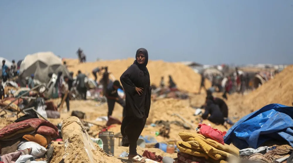 فلسطينيون يتفقدون الدمار في مخيم نازحين مؤقت بعد اقتحام الدبابات الإسرائيلية للمنطقة في خان يونس (أ.ف.ب)