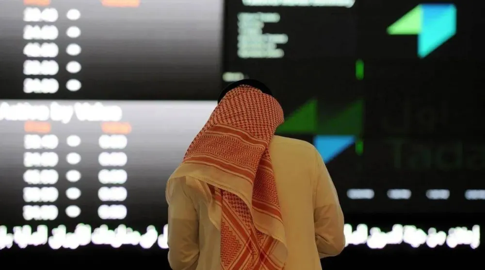 مستثمر يراقب شاشة التداول في «السوق المالية السعودية» بالرياض (أ.ف.ب)