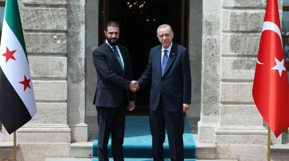 الرئيس التركي رجب طيب إردوغان مستقبِلاً الرئيس السوري الانتقالي أحمد الشرع بالمكتب الرئاسي بقصر دولمة بهشة في إسطنبول أمس (د.ب.أ)