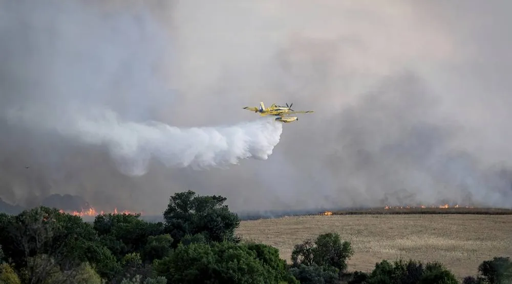  A firefighting plane drops water during efforts to extinguish a wildfire near Navalcarnero, on the outskirts of Madrid, Spain, Thursday, July 17, 2025. (A. Pérez Meca/Europa Press via AP) 